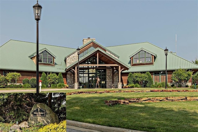 exterior space with a front lawn, a chimney, stone siding, and metal roof