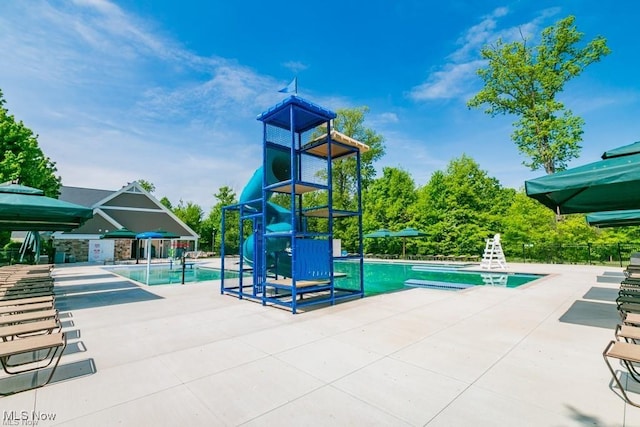 pool featuring a patio, a water play area, and fence