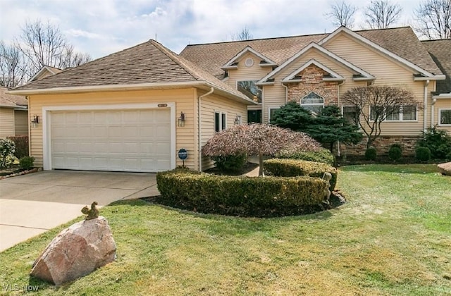 view of front facade featuring a garage, driveway, a front yard, and roof with shingles