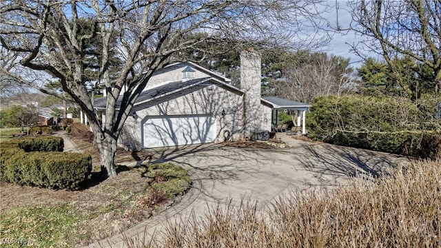 view of home's exterior with driveway, a chimney, and a garage