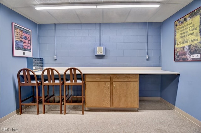 interior space featuring light countertops, concrete block wall, and baseboards