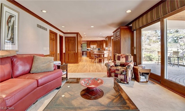 living area with visible vents, recessed lighting, and crown molding