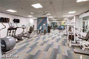 gym with a drop ceiling and carpet floors