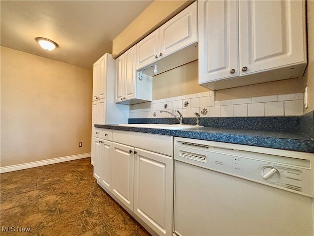 kitchen with a sink, dark countertops, white cabinetry, white dishwasher, and decorative backsplash