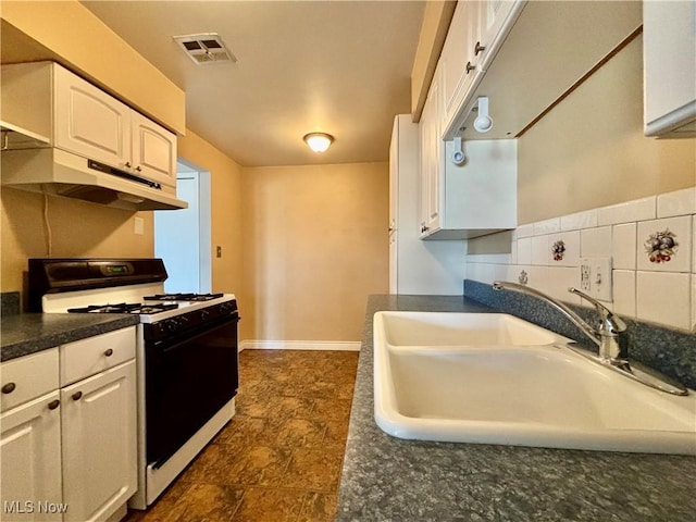 kitchen with visible vents, a sink, gas range oven, under cabinet range hood, and dark countertops