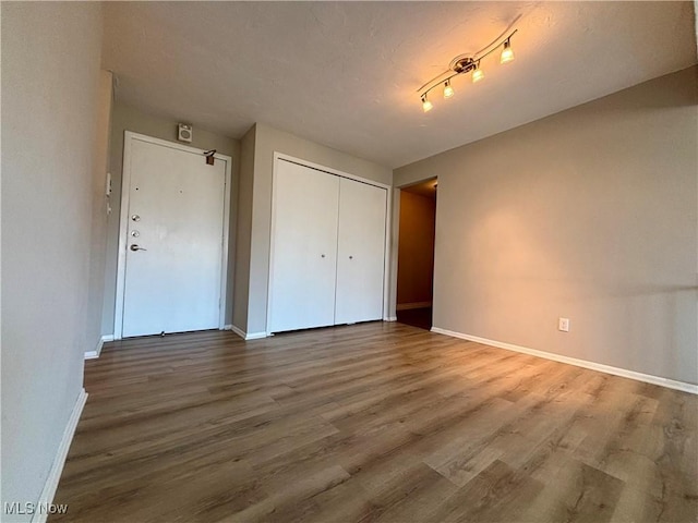 unfurnished bedroom with a closet, baseboards, and wood finished floors