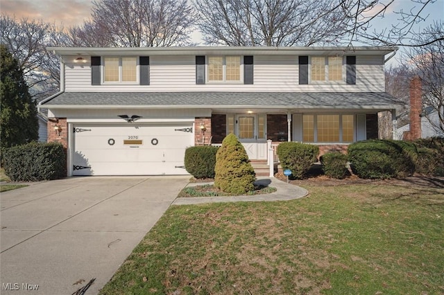 traditional-style house featuring driveway, a porch, an attached garage, a front lawn, and brick siding