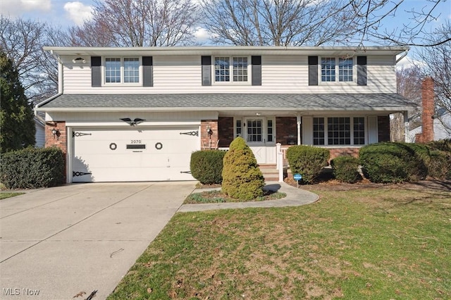 traditional-style house with brick siding, concrete driveway, a front yard, covered porch, and an attached garage