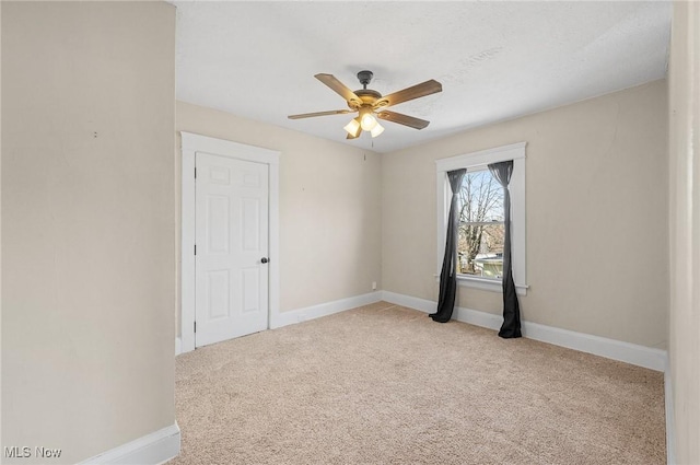 spare room featuring baseboards, a ceiling fan, and carpet flooring