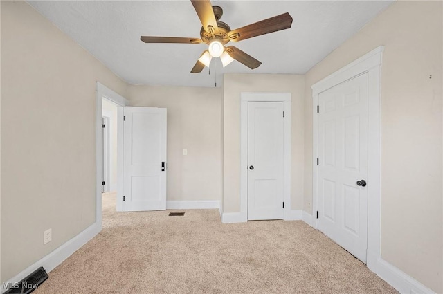 unfurnished bedroom with visible vents, baseboards, carpet floors, and ceiling fan