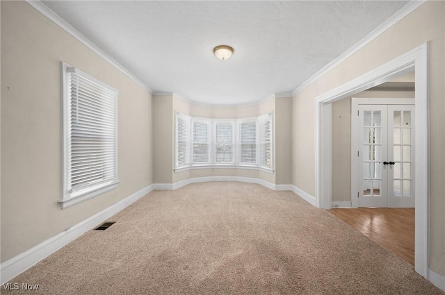 unfurnished room with french doors, crown molding, baseboards, and carpet floors