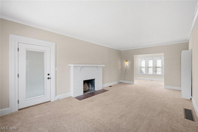 unfurnished living room featuring a brick fireplace, carpet flooring, baseboards, and visible vents