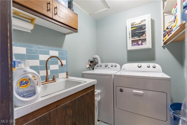 laundry area with separate washer and dryer, cabinet space, and a sink