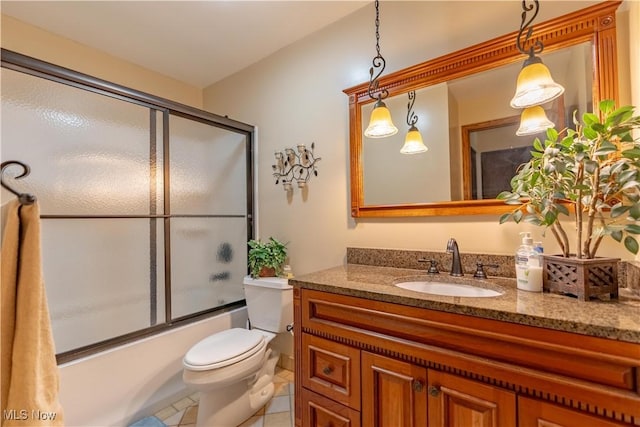 full bath featuring tile patterned floors, toilet, vanity, and bath / shower combo with glass door