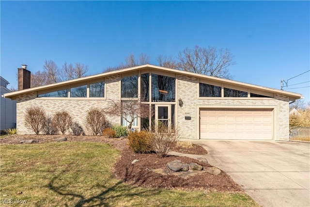 mid-century inspired home featuring brick siding, a garage, driveway, and a chimney