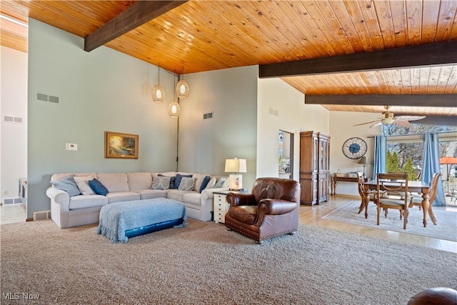 carpeted living area with visible vents, beam ceiling, high vaulted ceiling, wooden ceiling, and ceiling fan