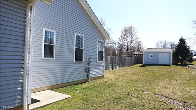 view of yard with an outdoor structure, a garage, and fence