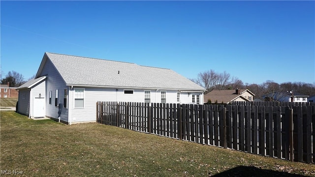 rear view of property with a lawn and fence