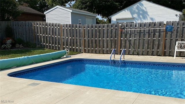 view of pool with a fenced in pool, an outdoor structure, and a fenced backyard