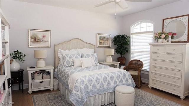 bedroom with a ceiling fan, baseboards, and wood finished floors