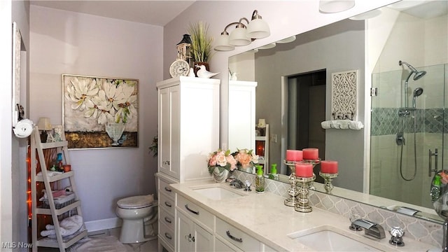 full bath featuring a sink, toilet, a stall shower, and double vanity