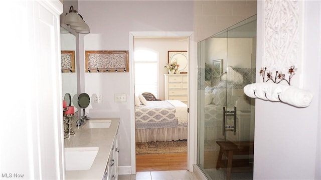 bathroom with a sink, double vanity, a stall shower, and ensuite bathroom