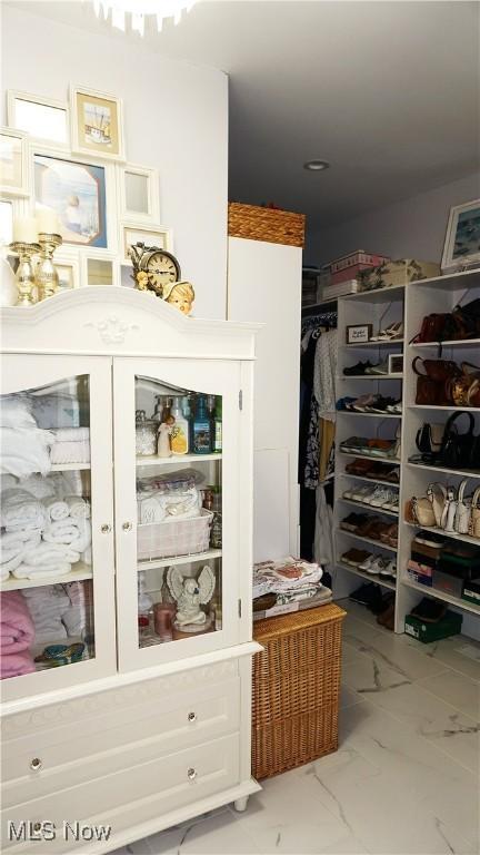 walk in closet with marble finish floor