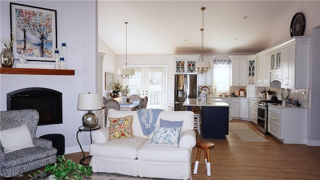 living area with vaulted ceiling and wood finished floors