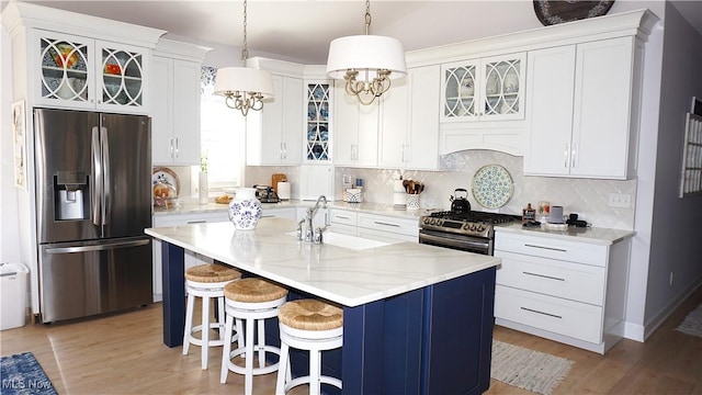 kitchen with a sink, decorative backsplash, appliances with stainless steel finishes, and a breakfast bar area