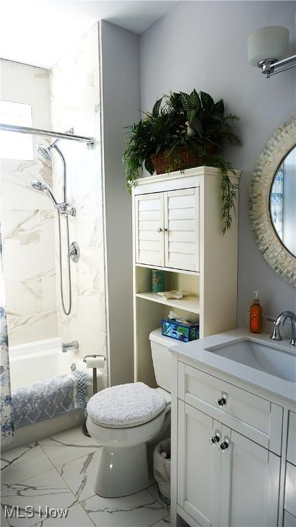 full bathroom featuring marble finish floor, toilet, vanity, and shower / bathtub combination with curtain