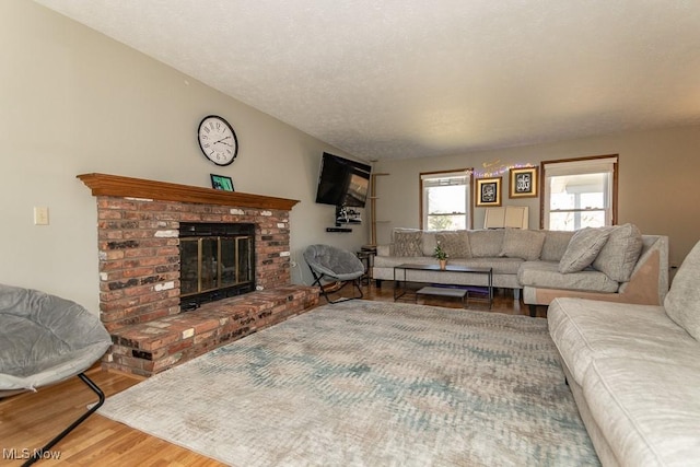 living area with a fireplace, wood finished floors, and a textured ceiling