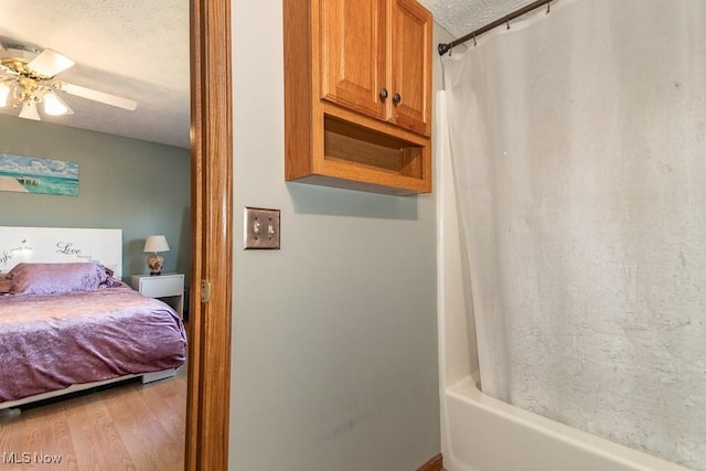 ensuite bathroom featuring ceiling fan, a textured ceiling, wood finished floors, and ensuite bathroom