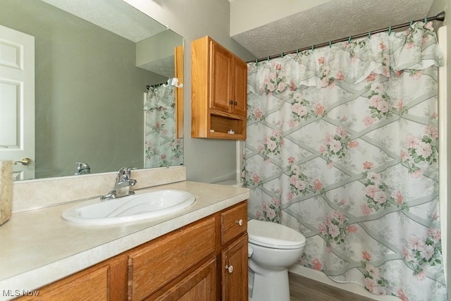 full bathroom with a shower with shower curtain, toilet, a textured ceiling, and vanity