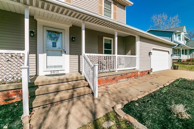 doorway to property with covered porch, concrete driveway, and a garage