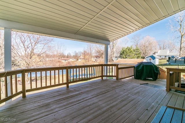 wooden terrace with area for grilling and fence