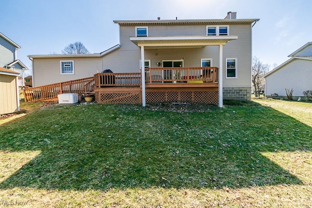 rear view of property with a yard, a wooden deck, and a chimney