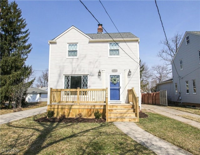 view of front of house featuring a chimney and a front lawn