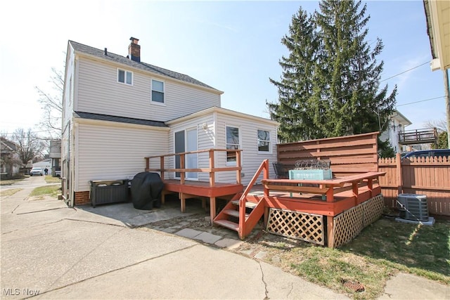 rear view of house featuring central AC unit, a deck, and fence