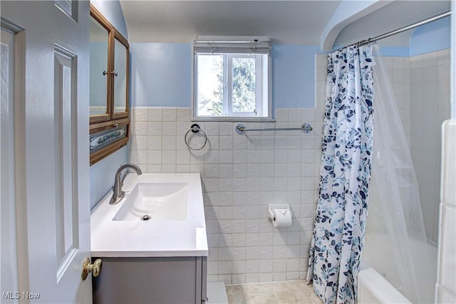 bathroom with vanity, tile walls, shower / bath combo, and tile patterned floors