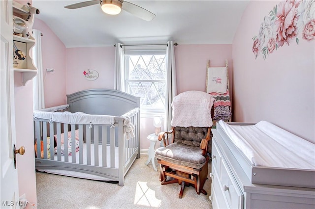 bedroom featuring a nursery area and a ceiling fan