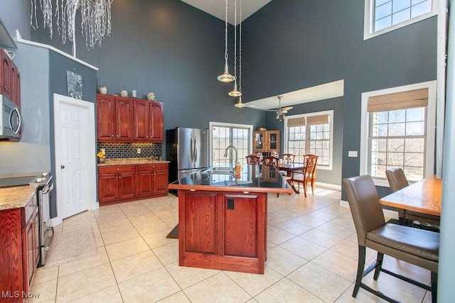 6603 Congress Rd, Spencer, OH 44275 - kitchen featuring a towering ceiling, stainless steel appliances, light tile patterned floors, a sink, and backsplash