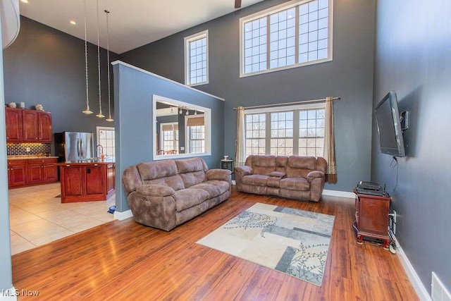 living area featuring visible vents, baseboards, and light wood finished floors