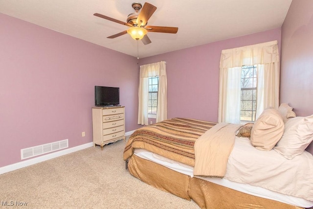 bedroom with multiple windows, baseboards, visible vents, and carpet floors