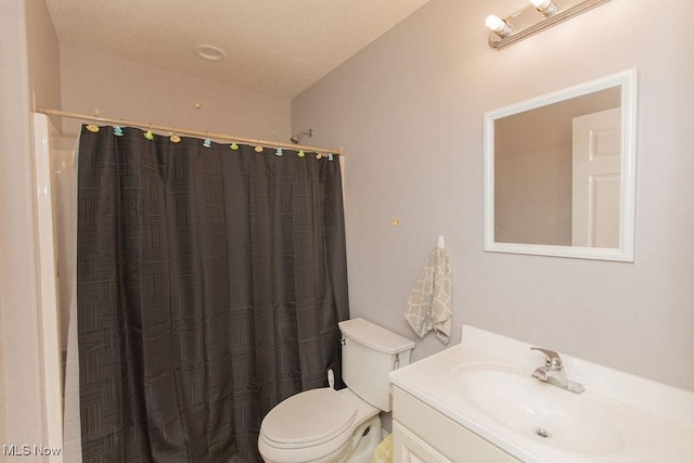 bathroom featuring a shower with shower curtain, toilet, and vanity