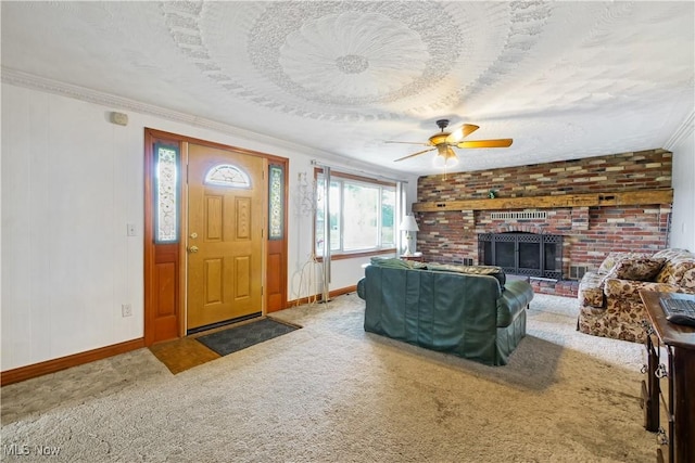 carpeted entrance foyer featuring a textured ceiling, a brick fireplace, ceiling fan, and crown molding