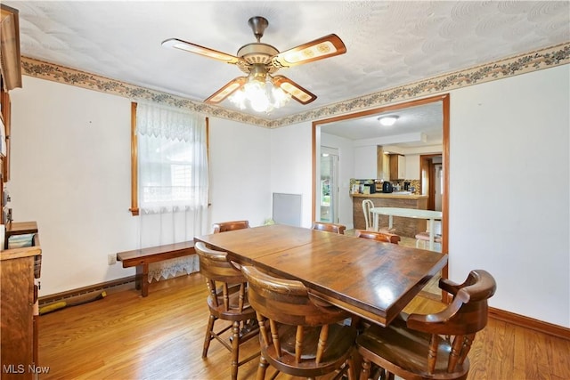 dining space with light wood-style flooring, baseboards, and ceiling fan