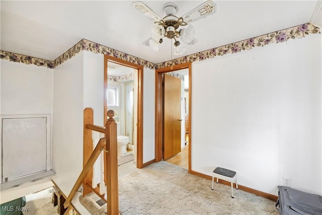 interior space with baseboards, an upstairs landing, light colored carpet, and ceiling fan