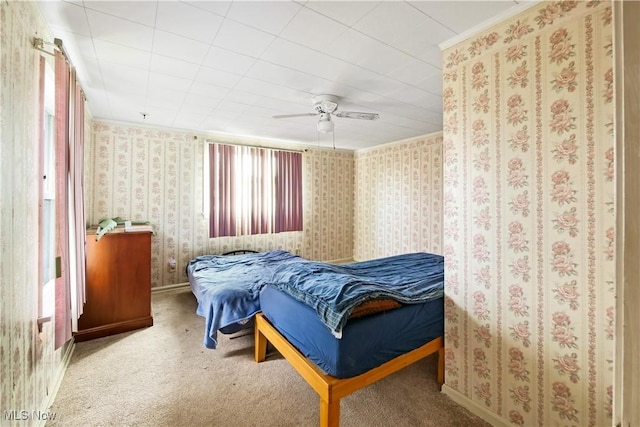 carpeted bedroom featuring wallpapered walls, a ceiling fan, and baseboards