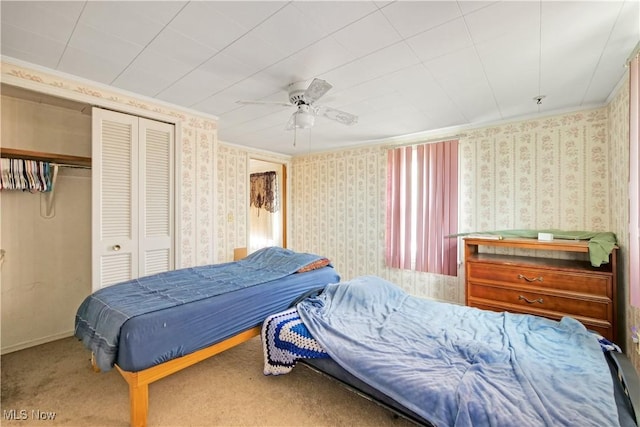 carpeted bedroom featuring a closet, baseboards, wallpapered walls, and ceiling fan