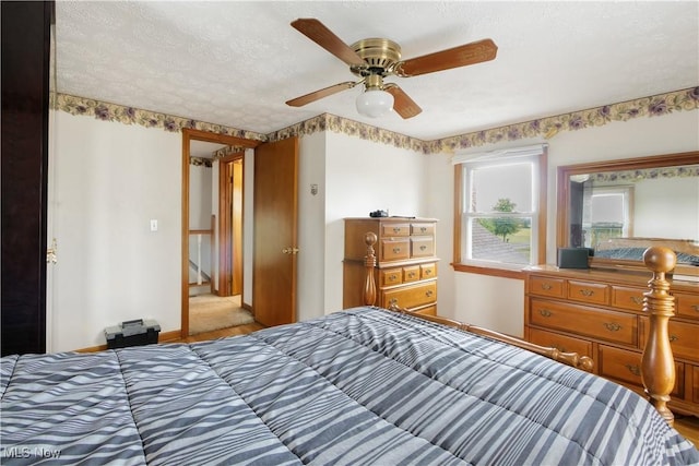 bedroom with baseboards, a textured ceiling, and a ceiling fan